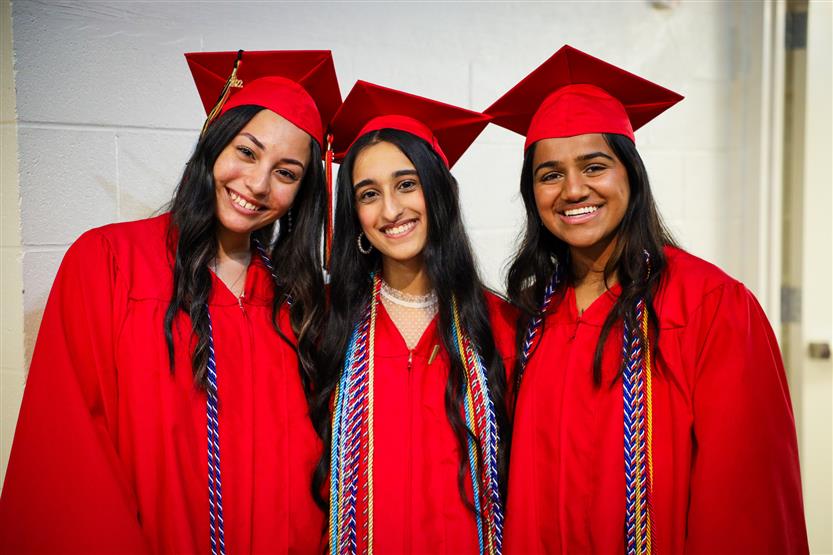 Students in red robes graduate
